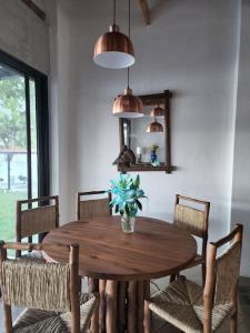a wooden table with chairs and a vase with a plant at Chalet Santa Teresita in Amatitlán