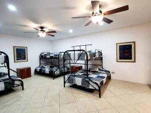 Cette chambre comprend 3 lits superposés et un ventilateur de plafond. dans l'établissement Chalet Santa Teresita, à Amatitlán