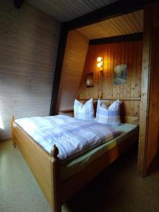 um quarto com uma cama e uma parede de madeira em Freyunger Berghaus em Freyung