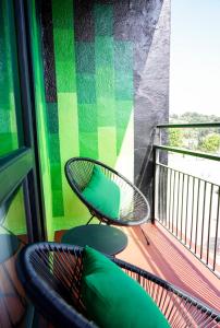a balcony with two chairs and a green wall at Lloret Vibe Affiliated by FERGUS in Lloret de Mar