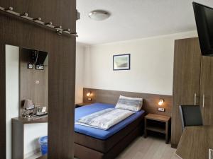 Kleines Zimmer mit einem Bett und einem TV in der Unterkunft LandGASTHOF Rose in Dammbach