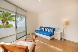 - un salon avec un canapé bleu et une table dans l'établissement Suites Turquesa, à Cozumel