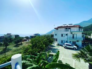 a white van parked in front of a building at Yard Paradise Rooms Dhermi in Dhërmi