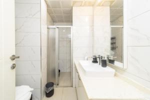 a white bathroom with a sink and a shower at Central Flat 10 min to Antalya Museum in Antalya