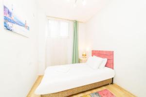 a white bedroom with a bed and a window at Central Flat 10 min to Antalya Museum in Antalya