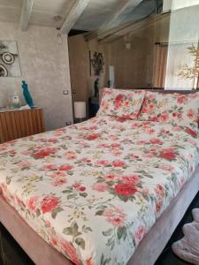 パルマ・ディ・モンテキアーロにあるTendu' Punta Bianca Glamping Campのベッドルームに花柄の掛け布団付きのベッド1台が備わります。
