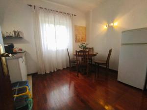 eine Küche und ein Esszimmer mit einem Tisch und einem Kühlschrank in der Unterkunft Casa Hóspedes Polido in Termas de Sao Pedro do Sul