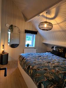 1 dormitorio con 1 cama grande y espejo en Vakantiehuisje Fie, en Dilsen-Stokkem