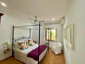 a bedroom with a black canopy bed with purple sheets at Finca Amer in Sa Pobla