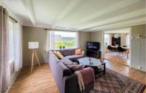 ein Wohnzimmer mit einem Sofa und einem Tisch in der Unterkunft Beautiful Home In Sveio With Wifi in Kvalvåg