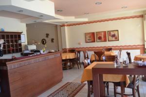 a restaurant with a dining room with tables and chairs at Vila Europe R in Paralia Katerinis