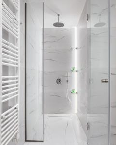 アテネにあるAcropolis Sherlock Residenceの白いバスルーム(ガラスドア付きのシャワー付)