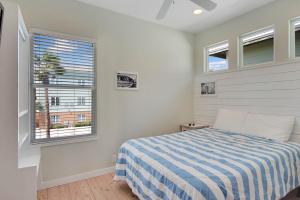 a bedroom with a bed and two windows at Beach Club 2 in Port Aransas