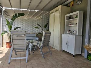 Habitación con 2 sillas, mesa y armario en Casa Elia - Puglia Mia Apartments, en Monopoli