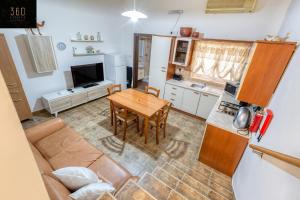 een woonkamer met een tafel en een keuken bij Lovely, comfy 2BR home with comfy sofa w/WIFI & AC by 360 Estates in St Paul's Bay
