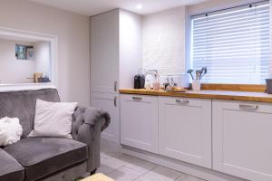 a kitchen with a couch and a sink and a counter at The Hideaway in Southampton