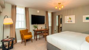 a hotel room with a bed and a desk and a television at The Fleet in Dublin