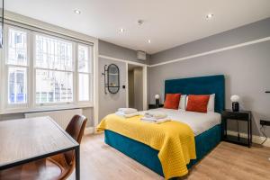 a bedroom with a blue bed and a table at Philbeach Gardens Rooms in London
