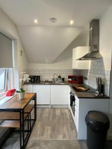 a kitchen with white cabinets and a wooden table at Adorable Flat in Maidstone - Sleeps 3 in Kent