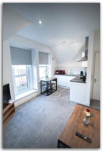 a large white kitchen with a table and a counter at Adorable Flat in Maidstone - Sleeps 3 in Kent