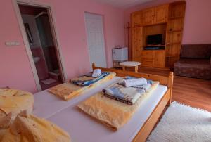2 camas en una habitación con paredes rosas en Kovács Vendégház en Vonyarcvashegy