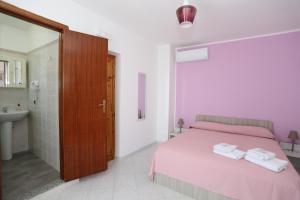um quarto com uma cama e uma casa de banho com um lavatório em B&B Saracinello em Praia a Mare