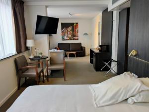 a hotel room with a bed and a living room at Tower Hotel Aalst in Aalst