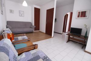 ein Wohnzimmer mit einem Sofa und einem TV in der Unterkunft ApartamentoSolPraia - Cruzeiro in Portimão
