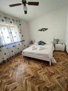 a bedroom with a bed and a wooden floor at La Perla Marina House in Chiavari