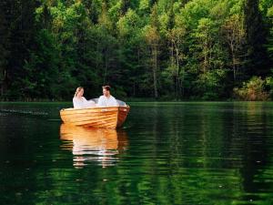 een man en vrouw in een boot op een meer bij Seehotel Grundlsee in Grundlsee