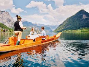 een groep mensen in een houten boot op een meer bij Seehotel Grundlsee in Grundlsee