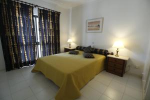 ein Schlafzimmer mit einem Bett mit zwei Lampen in der Unterkunft ApartamentoSolPraia - Cruzeiro in Portimão