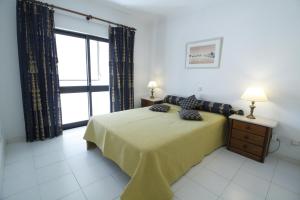 ein Schlafzimmer mit einem Bett und einem großen Fenster in der Unterkunft ApartamentoSolPraia - Cruzeiro in Portimão