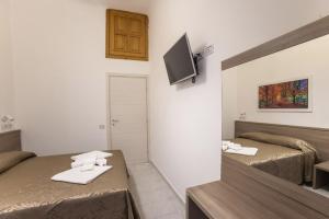 Habitación pequeña con 2 camas y espejo. en Hotel Orbis en Roma