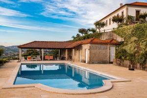 a swimming pool in front of a house at Casa do Amial in Castelo de Paiva