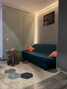 a bedroom with a blue bed and a table at VIVO Loft Short Stay in Baia Mare