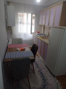 a small kitchen with a table and a refrigerator at goldwinn turizm in Trabzon