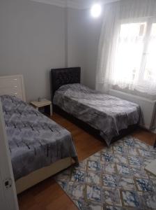 een slaapkamer met 2 bedden en een raam bij goldwinn turizm in Trabzon