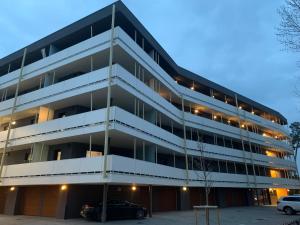 an apartment building with a car parked in front of it at Római Ház Apartman in Siófok