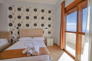 ein Schlafzimmer mit einem Bett, Handtüchern und einem Fenster in der Unterkunft Hotel Panorama in Himarë + 175 Fotos