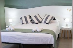 a bedroom with a white bed with striped pillows at Vista Mare in Mola di Bari