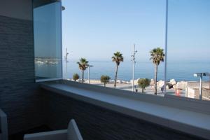 a room with a view of the ocean and palm trees at Vista Mare in Mola di Bari