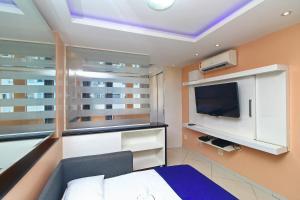 a bedroom with a bed and a tv and a window at Rio Spot Homes C046. in Rio de Janeiro