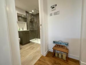 uma casa de banho com uma cabina de duche ao nível do chão e um WC. em The Garden Room at Amelia Cottage em Whiting Bay