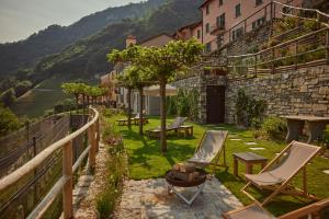 Elle offre une vue sur un jardin avec des chaises et un bâtiment. dans l'établissement "La Casa dei Gelsi" - Panorama Lodge MONTE GENEROSO, à Scudellate