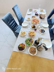un lungo tavolo con piatti di cibo sopra di Hotel Kolsay Eki Agayindy a Kurmenty