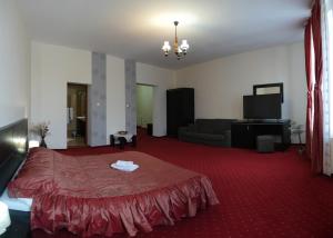 a living room with a bed and a couch at Hotel Rubin*** in Gheorgheni