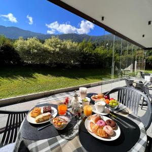 ブルーニコにあるB&B Boutique Apartment Oberwiesenのバルコニーにテーブルと朝食用の食材を用意しています。