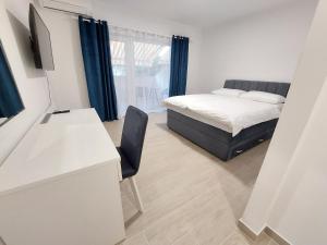 sypialnia z łóżkiem i biurkiem z krzesłem w obiekcie Guest House Nina w mieście Novigrad