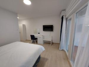 a bedroom with a bed and a desk and a tv at Guest House Nina in Novigrad Istria
